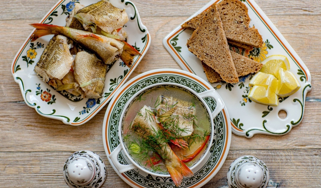 Уха на столе с хлебом и лимоном