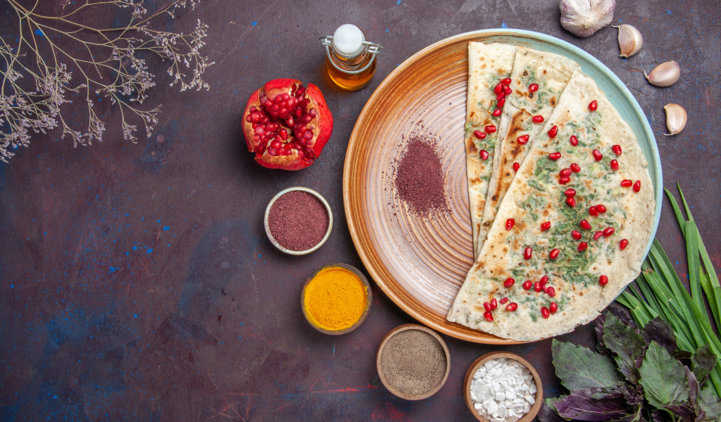 Лепешки на столе со специями и зеленью