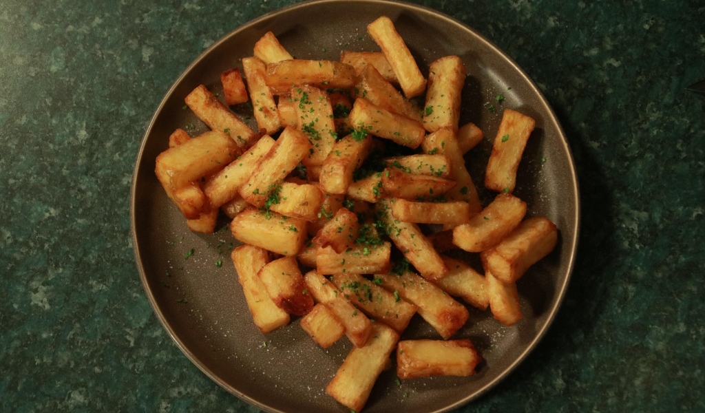 Картофель фри на большой тарелке на столе