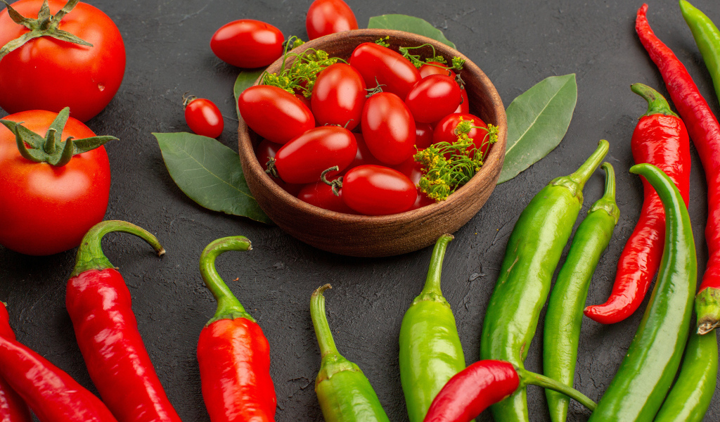 Свежие помидоры на столе с острым перцем