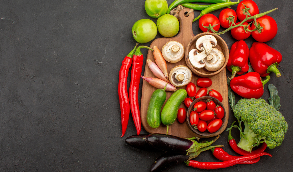 Свежие овощи на разделочной доске на столе