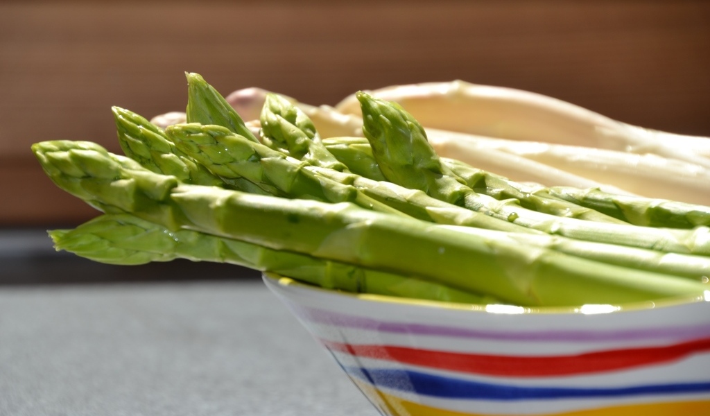 Зеленая спаржа в тарелке на столе