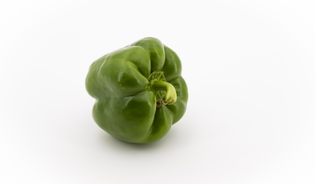 Зеленая паприка на белом фоне