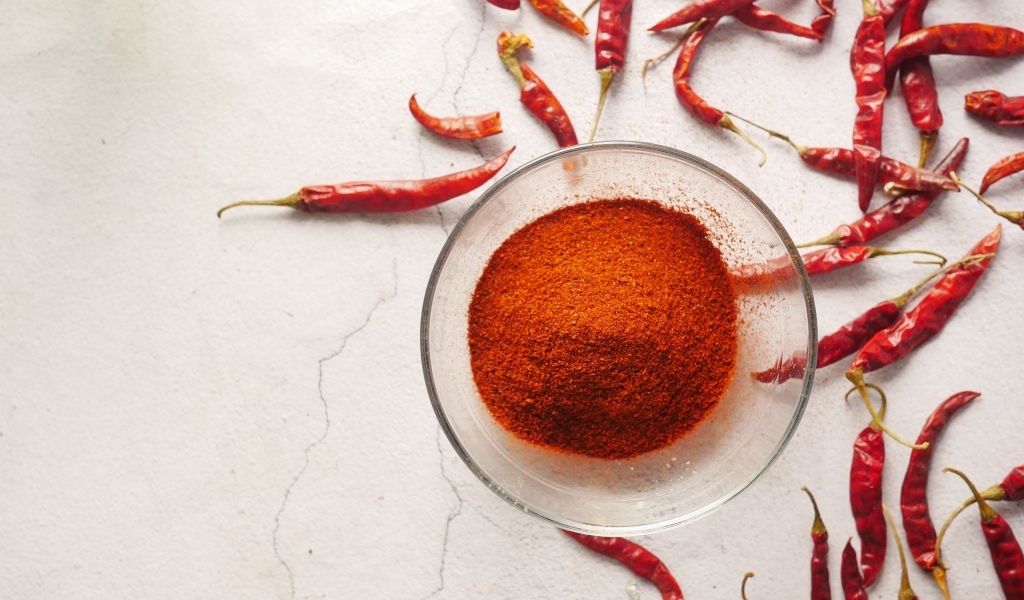 Молотый жгучий красный перец на столе