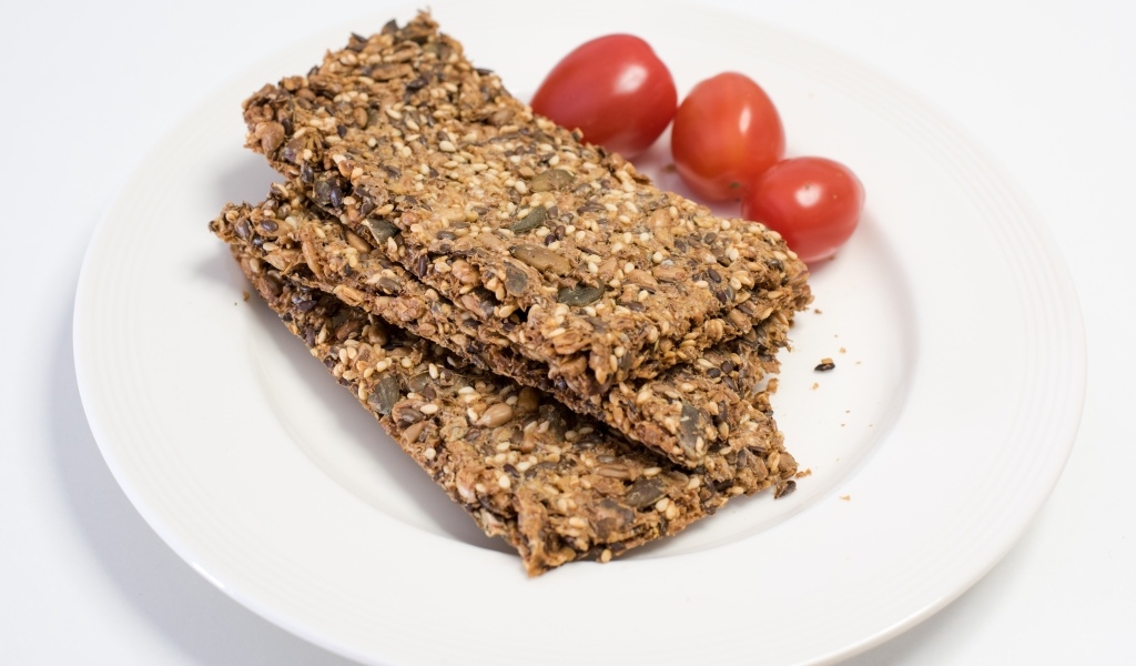 Полезны злаковые хлебцы на тарелке с помидорами