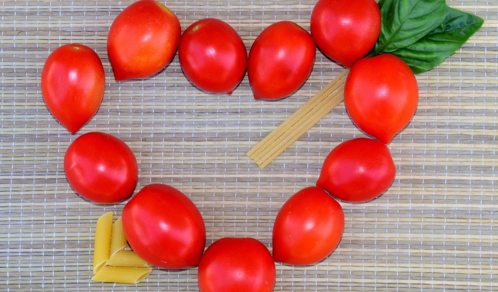 Сердце из помидоров на столе с макаронами