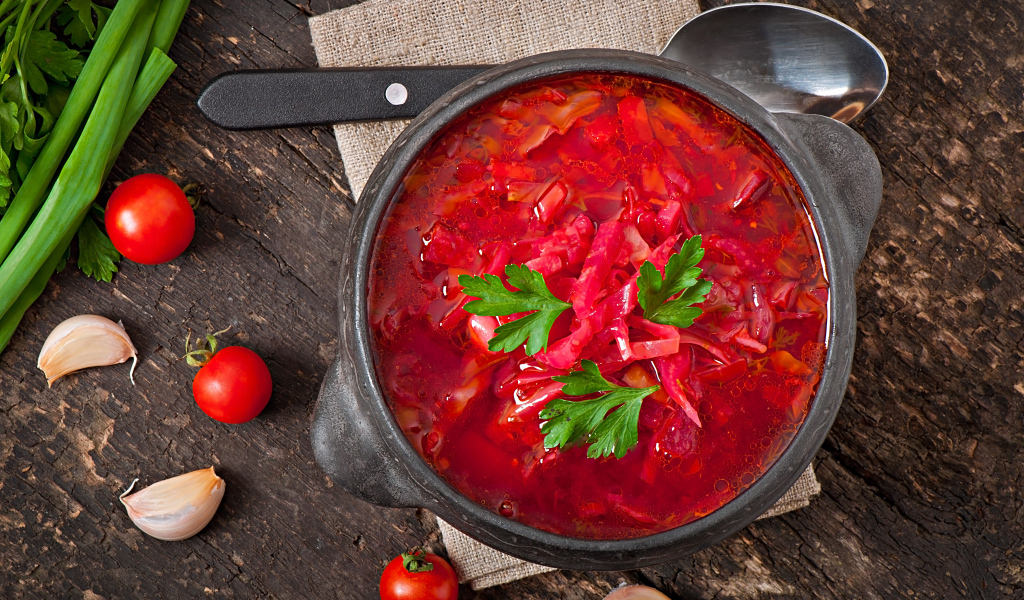 Большая тарелка красного борща на столе