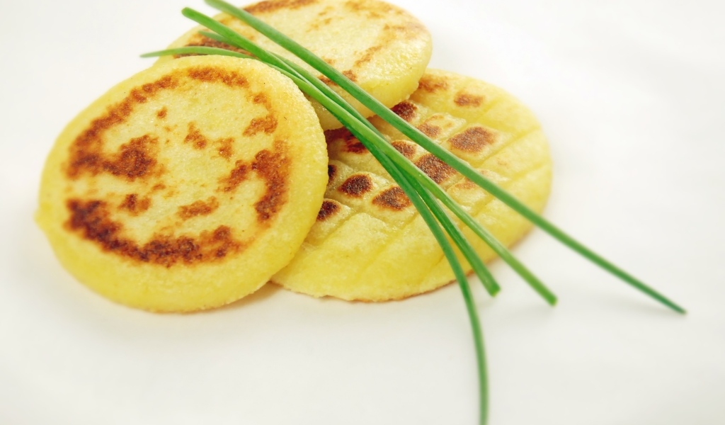 Картофельные оладьи с зеленом луком на столе