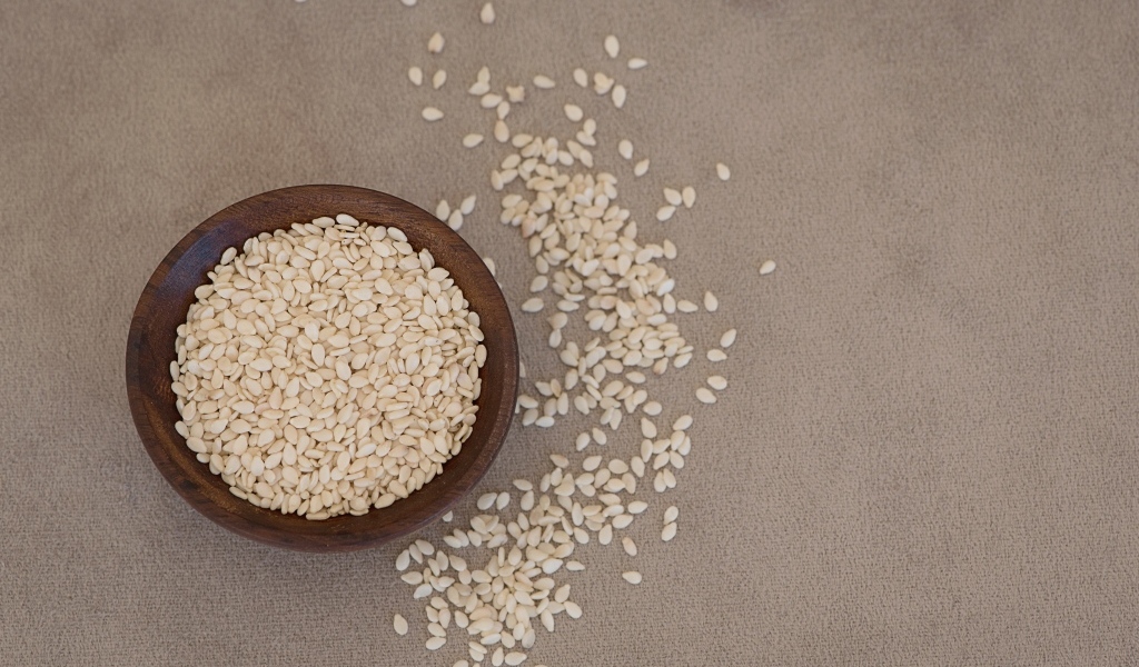 Зерна кунжута в деревянной миске на столе