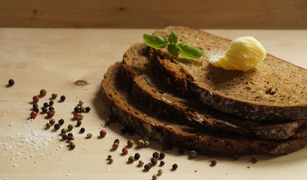 Нарезанный хлеб с маслом и перцем на столе