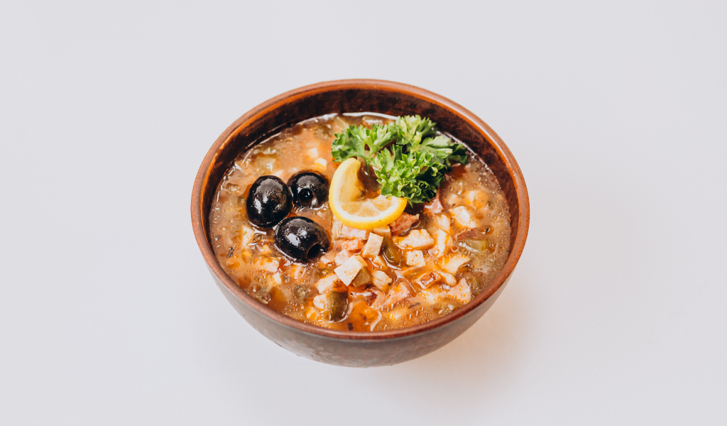 Солянка в тарелке на сером фоне