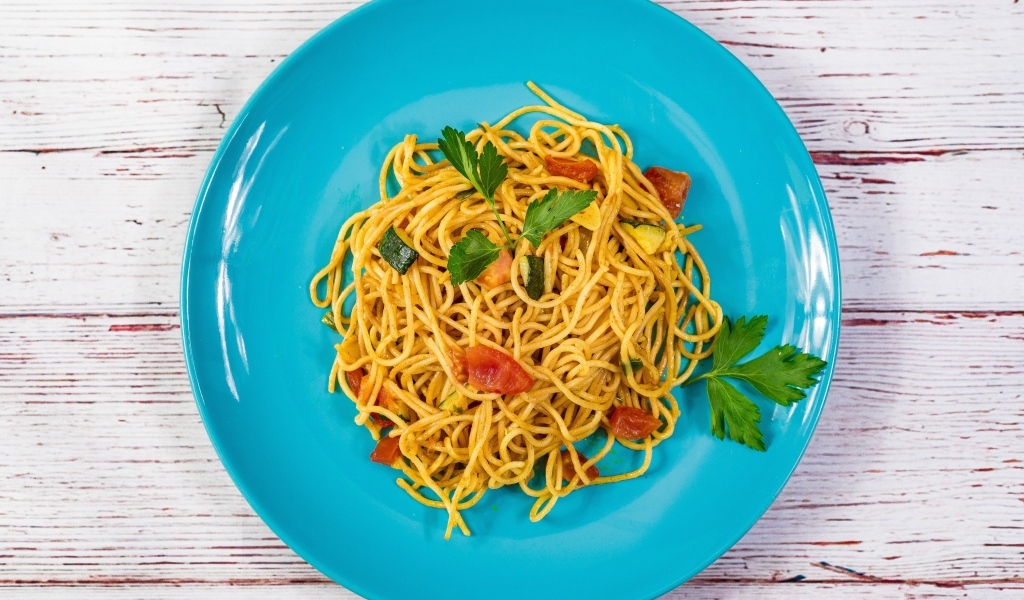 Спагетти с овощами  на голубой тарелке