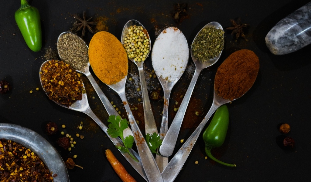 Ложки с ароматными специями на черном столе