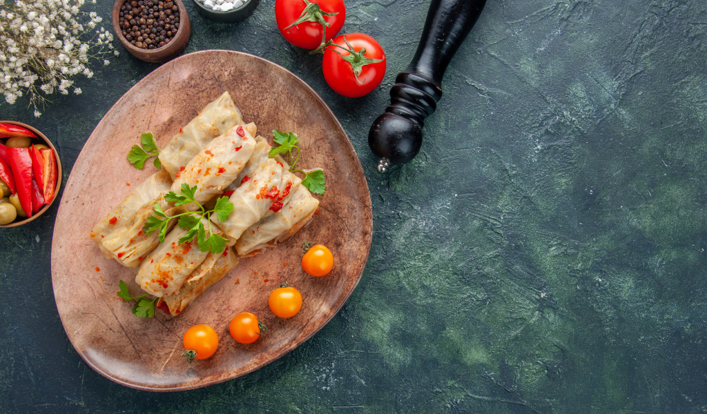 Голубцы на столе с помидорами и специями