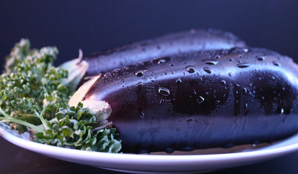 Два баклажана на тарелке с зеленью