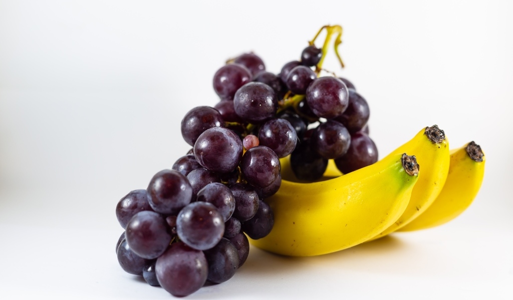 Гроздь винограда с бананами на столе