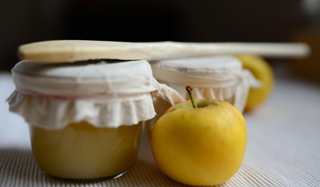 Яблочное пюре в банке на столе с плодами