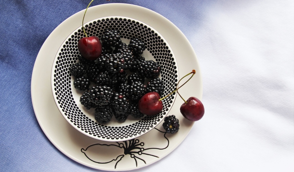 Ягоды ежевики и черешни на столе
