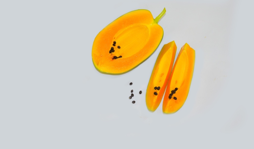 Разрезанная папайя на сером фоне