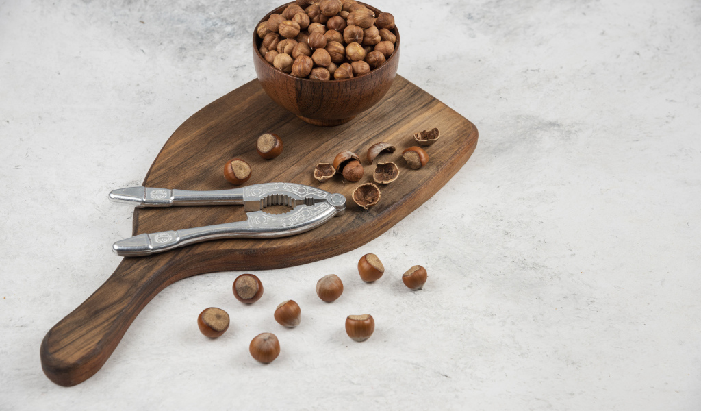 Лесные орехи на сером столе с разделочной доской