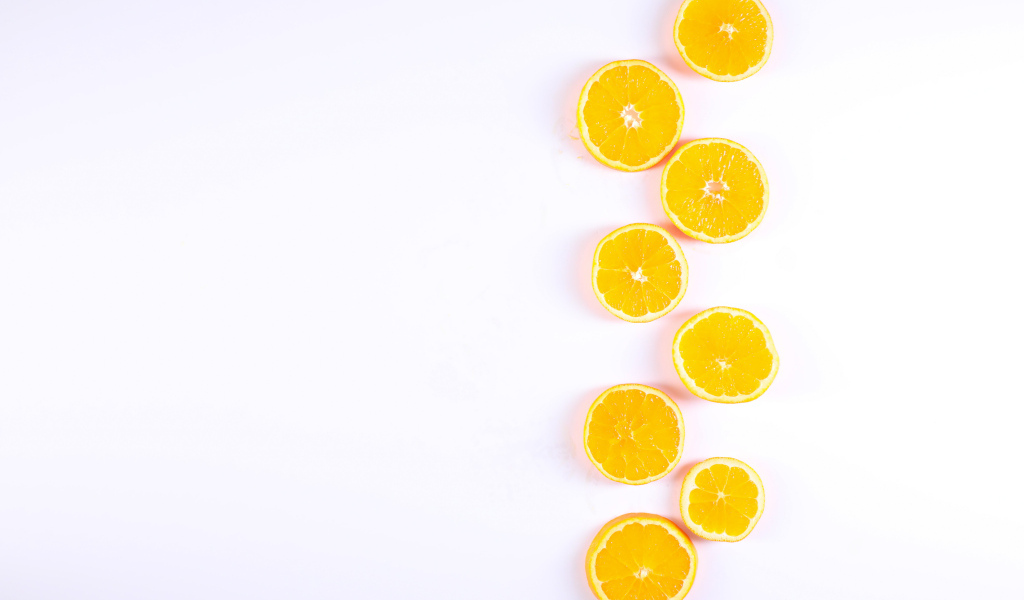Много половинок лимона и апельсина на белом фоне