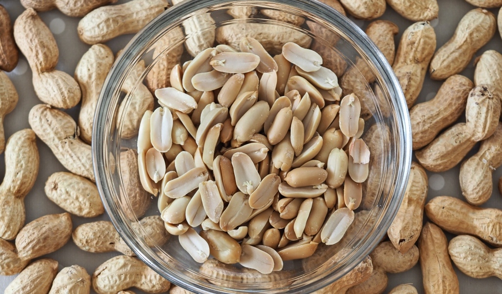 Арахис в стеклянной тарелке на столе 