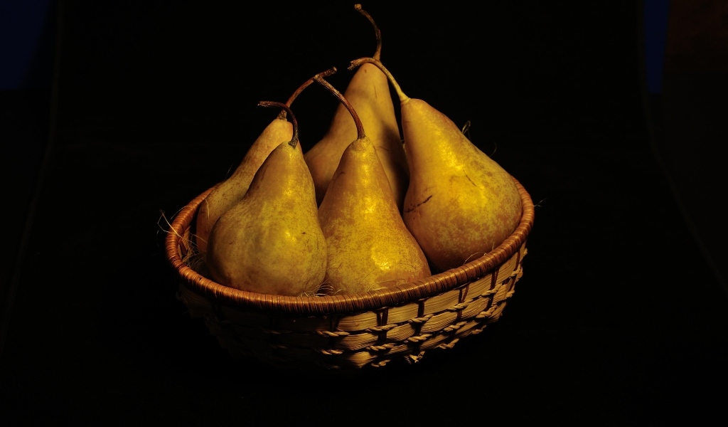 Груши в корзине на черном фоне