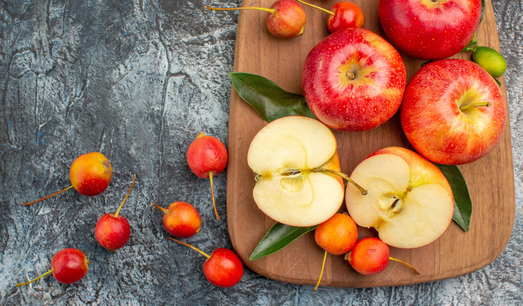 Нарезанные яблоки на деревянной доске на столе