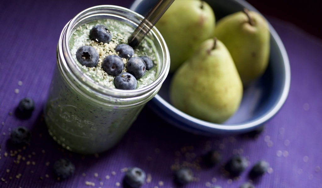 Смузи с ягодами черники на столе с грушами