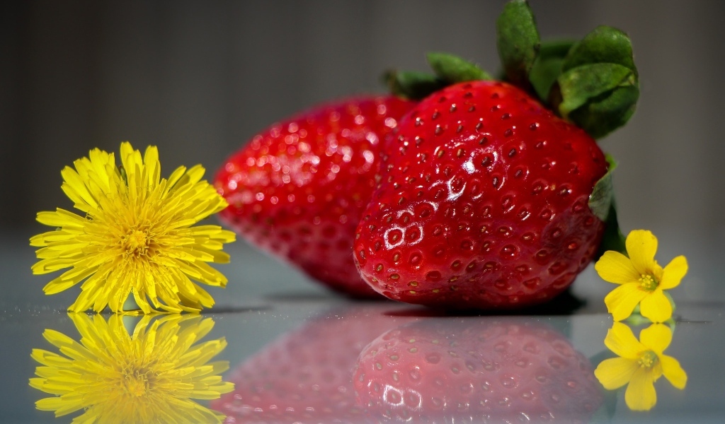 Клубника с одуванчиками на зеркальной поверхности