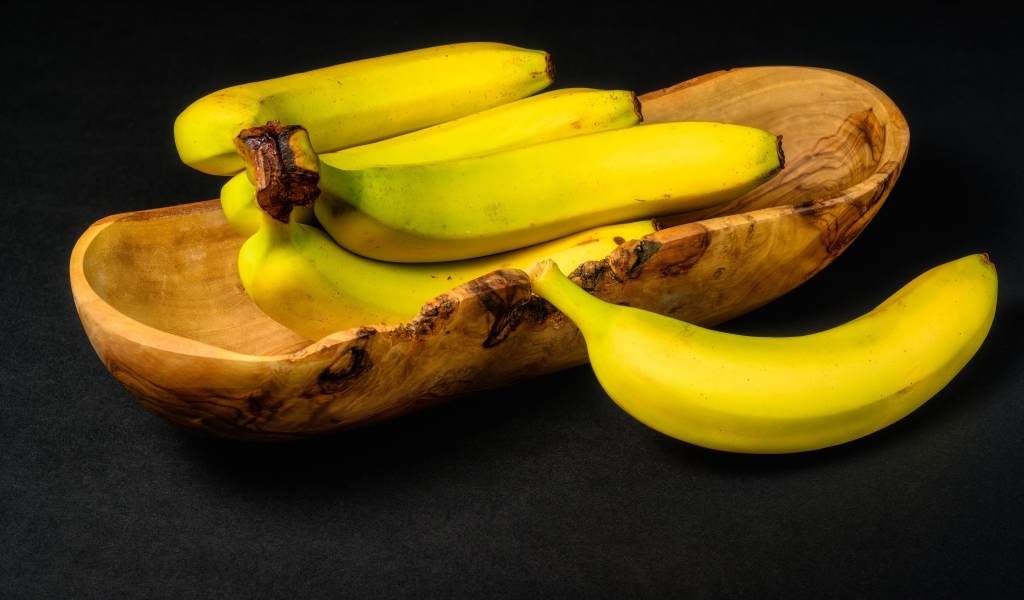 Деревянная чаша с бананами на столе