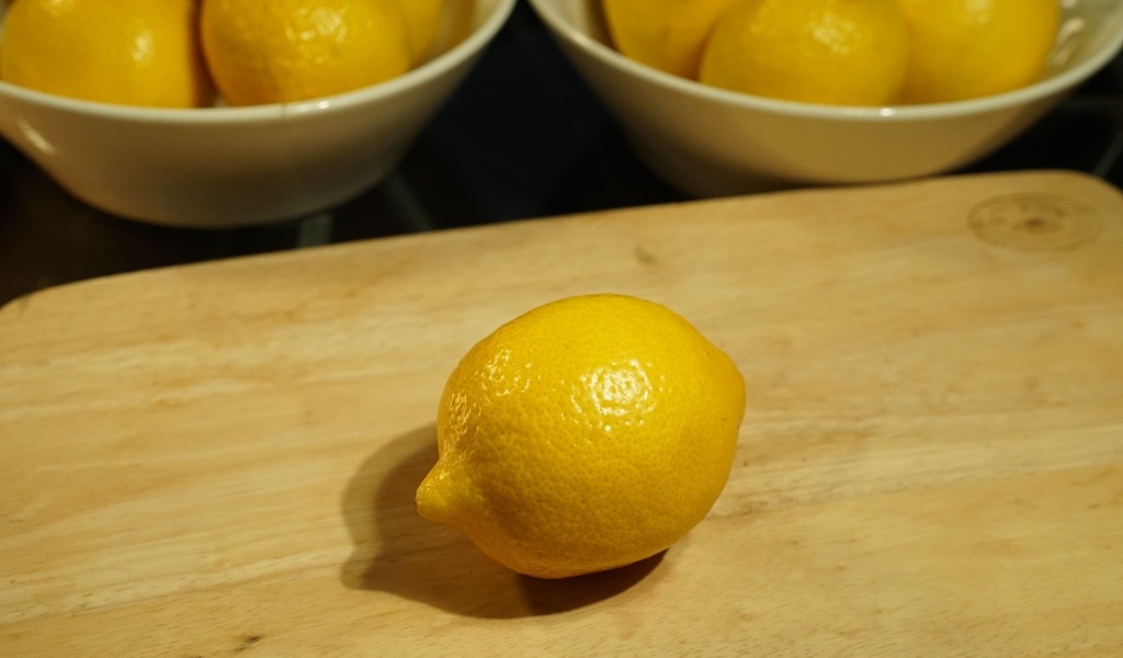 Желтый лимон на деревянной доске на столе