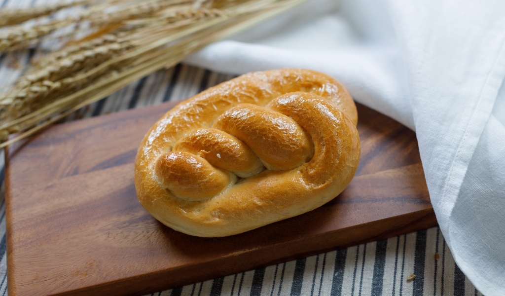 Булочка на столе с колосьями пшеницы