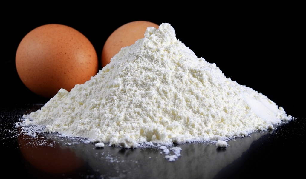 Мука на черном столе с куриными яйцами