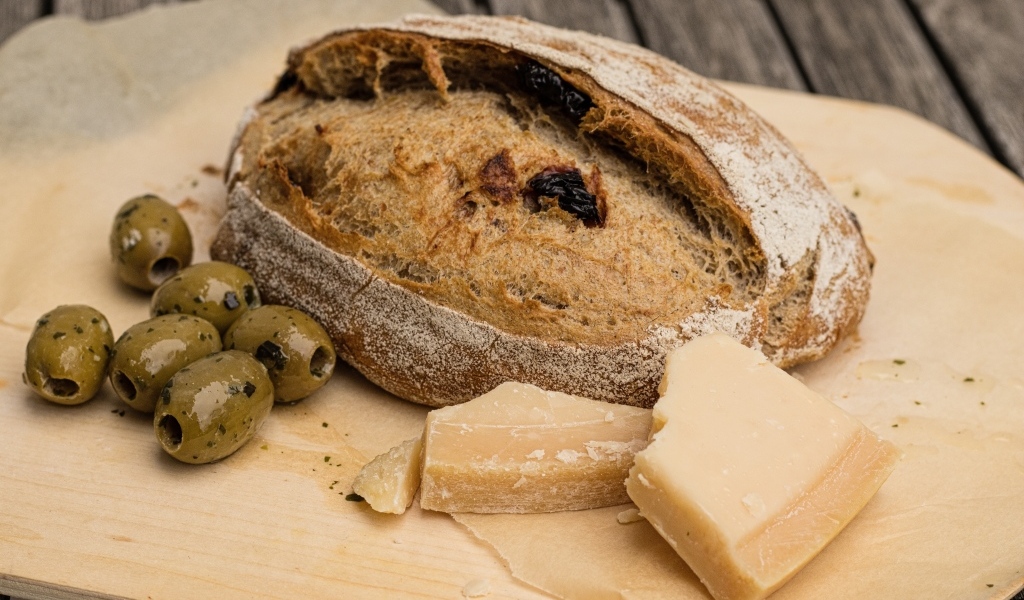 Буханка хлеба с сыром и оливками