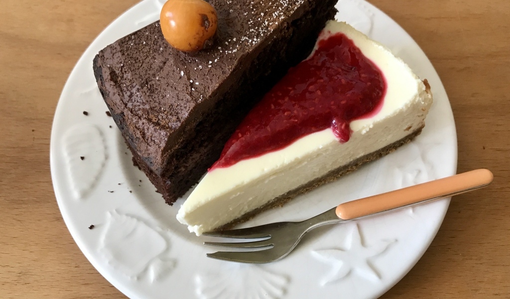 Кусок шоколадного торта и чизкейка на тарелке