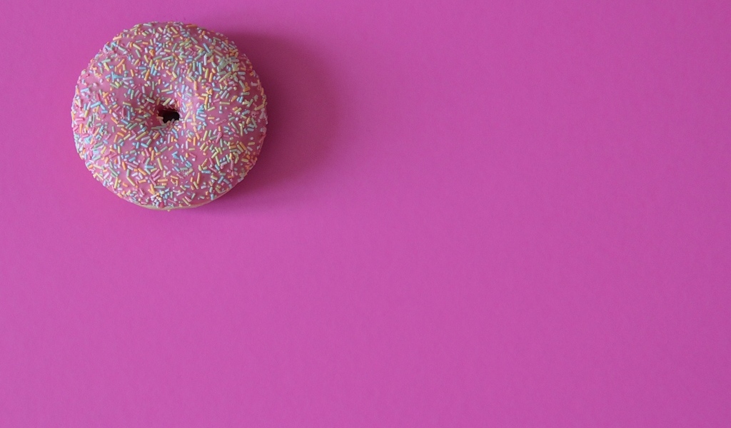 Аппетитный донат с глазурью на розовом фоне