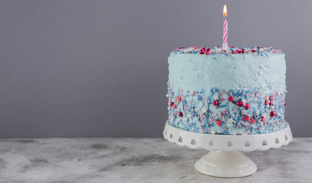 Праздничный торт в голубой глазури с одной свечкой
