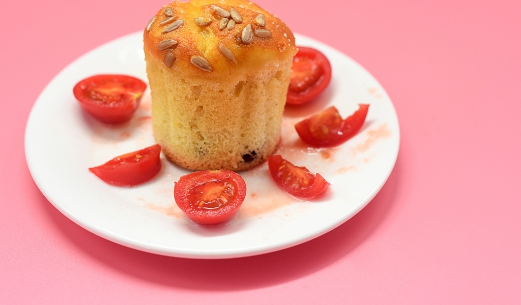 Кекс с помидорами черри на белой тарелке