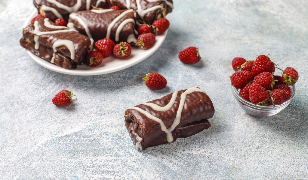 Шоколадные рулетики с ягодами малины на столе