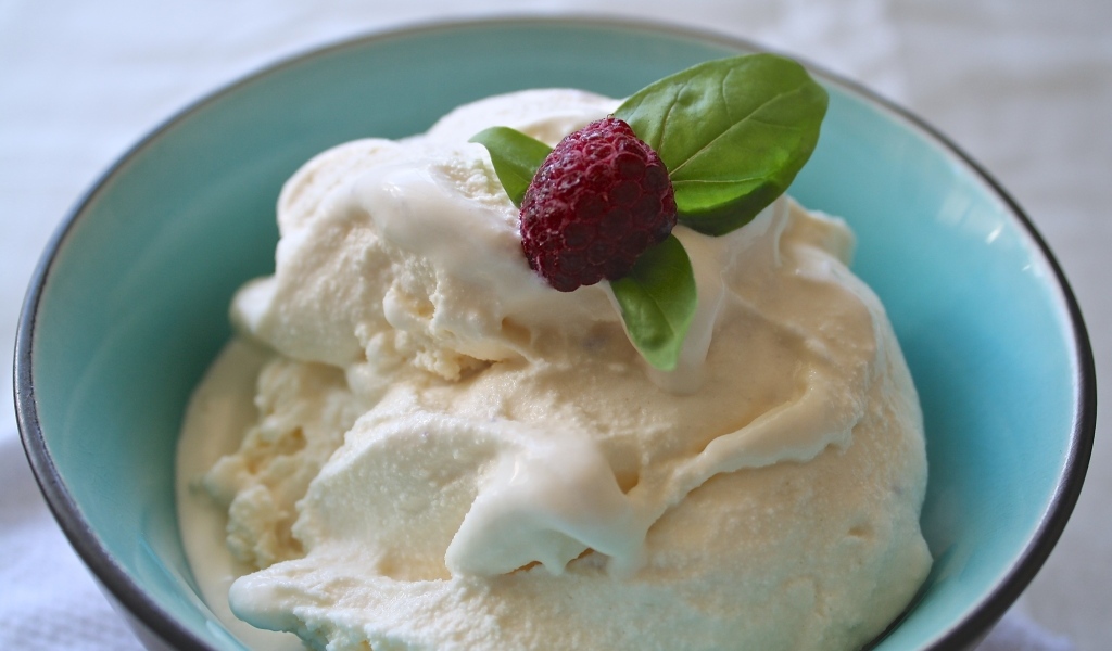 Сливочное мороженое в тарелке с ягодой малины