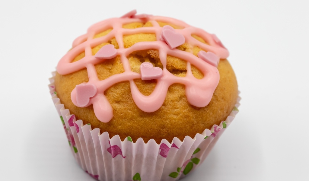 Кекс с клубничной глазурью на сером фоне