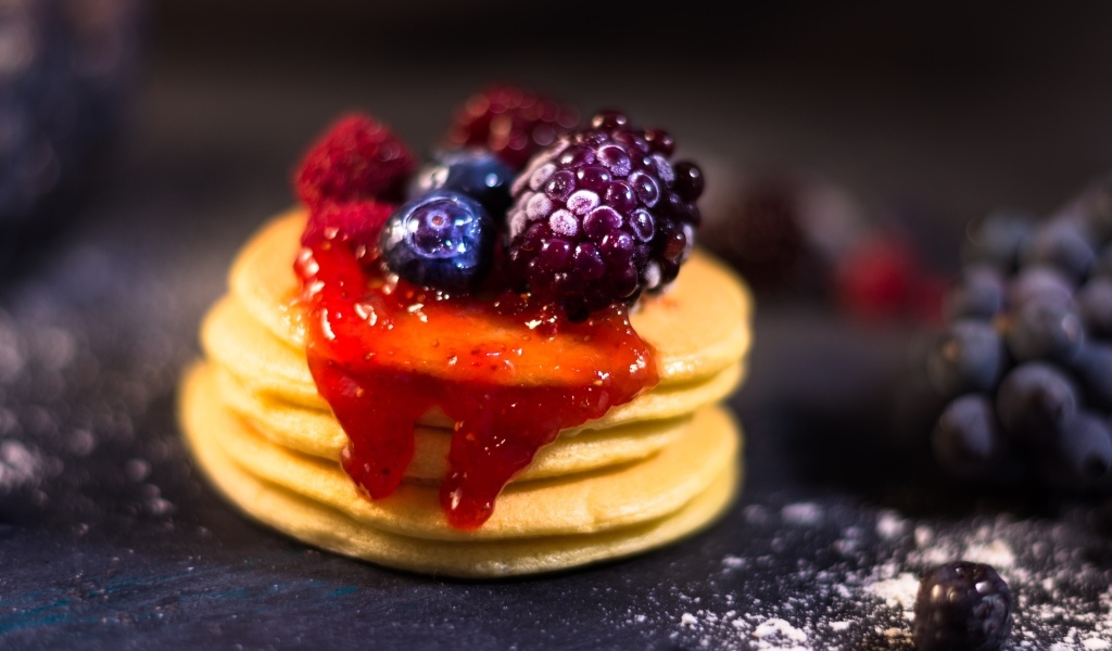 Оладьи с джемом и ягодами на столе