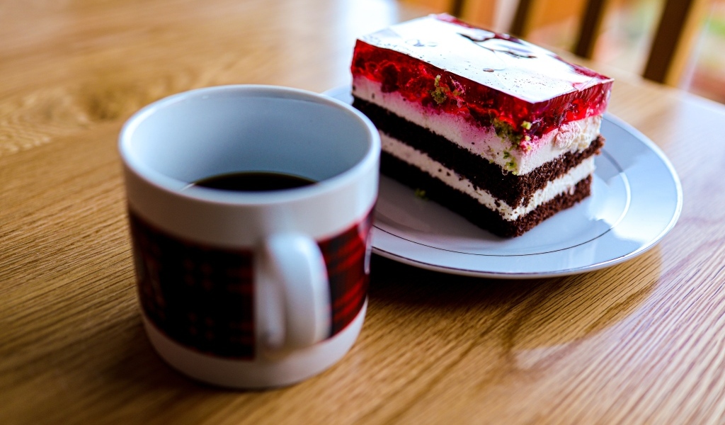 Кусок торта с чашкой кофе на деревянном столе