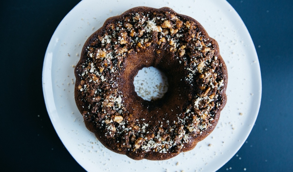 Круглый шоколадный кекс на большой белой тарелке