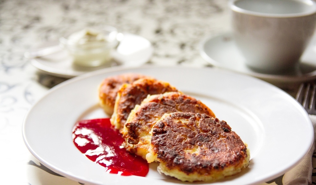 Румяные сырники на тарелке с джемом на завтрак