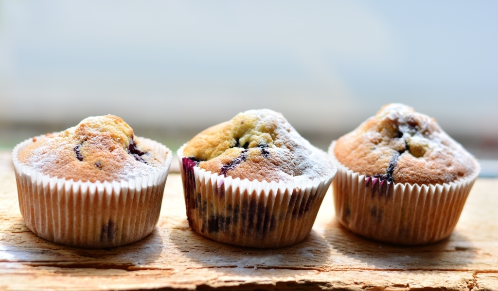 Три вкусных сладких кекса с сахарной пудрой на столе