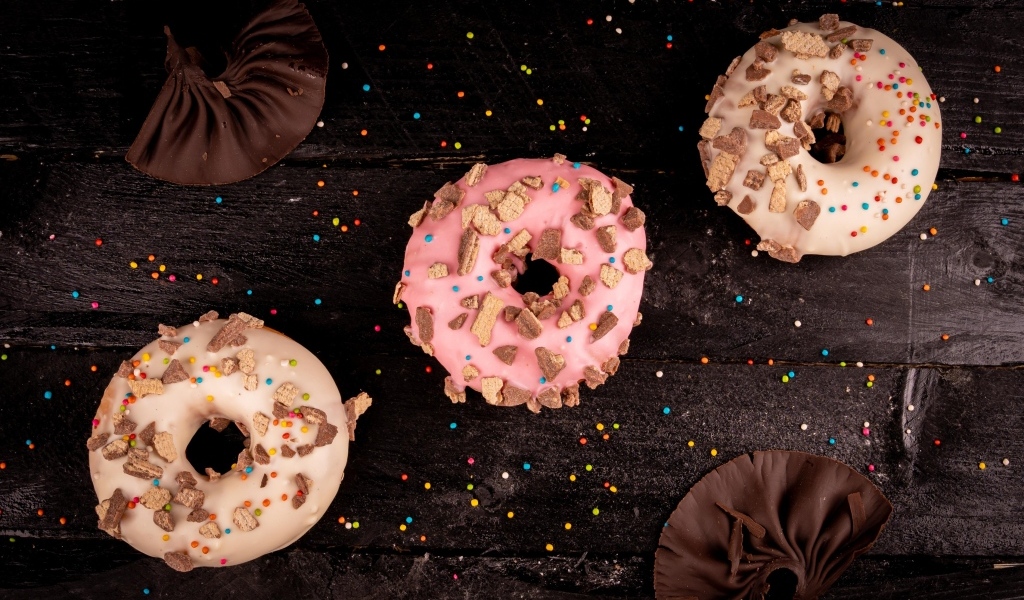 Три сладких пончика на черном столе
