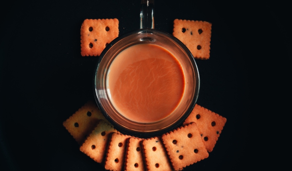 Чашка какао с печеньем на черном фоне