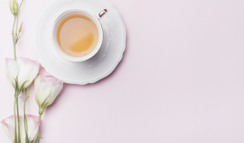 Чашка чая на розовом фоне с цветами эустомы